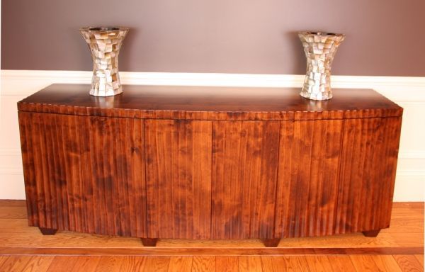 A wooden cabinet with two vases on top of it