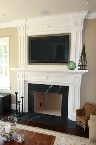 A living room with a fireplace and a flat screen tv
