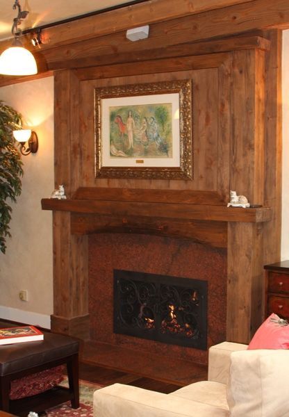 A living room with a fireplace and a picture on the wall