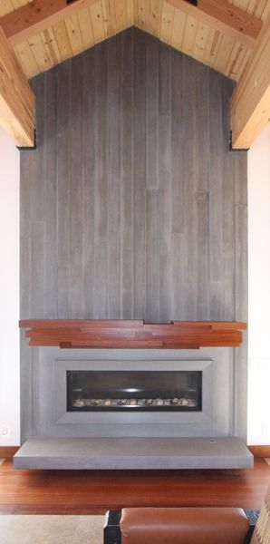 A fireplace in a living room with a wooden ceiling