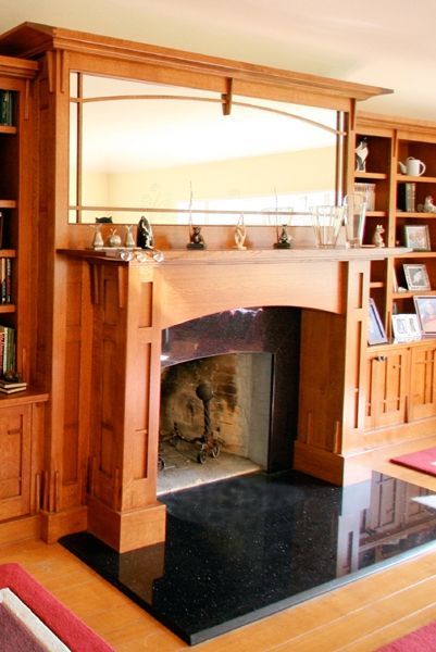 A living room with a fireplace surrounded by bookshelves