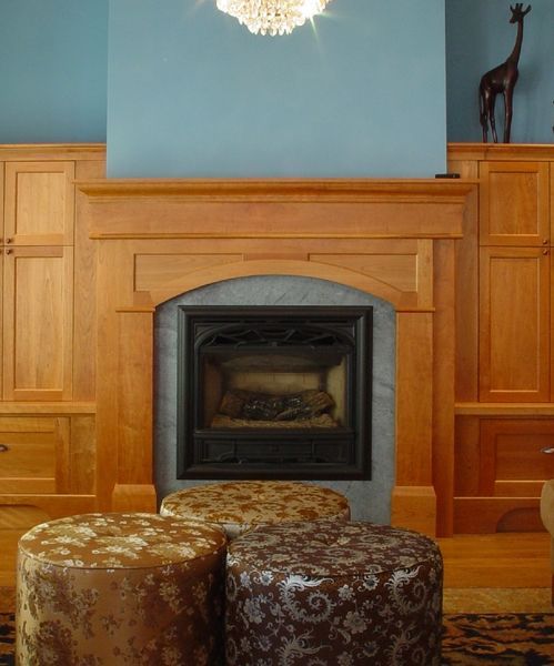 A living room with a fireplace and two ottomans