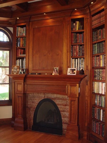 A living room with a fireplace surrounded by bookshelves