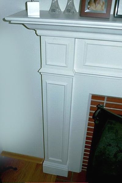 A white fireplace with a picture on top of it