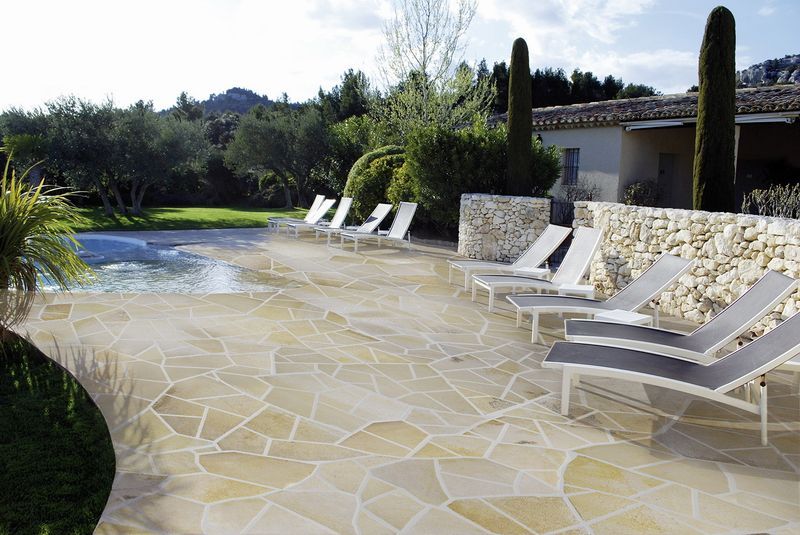 Un patio con sedie e una piscina sullo sfondo