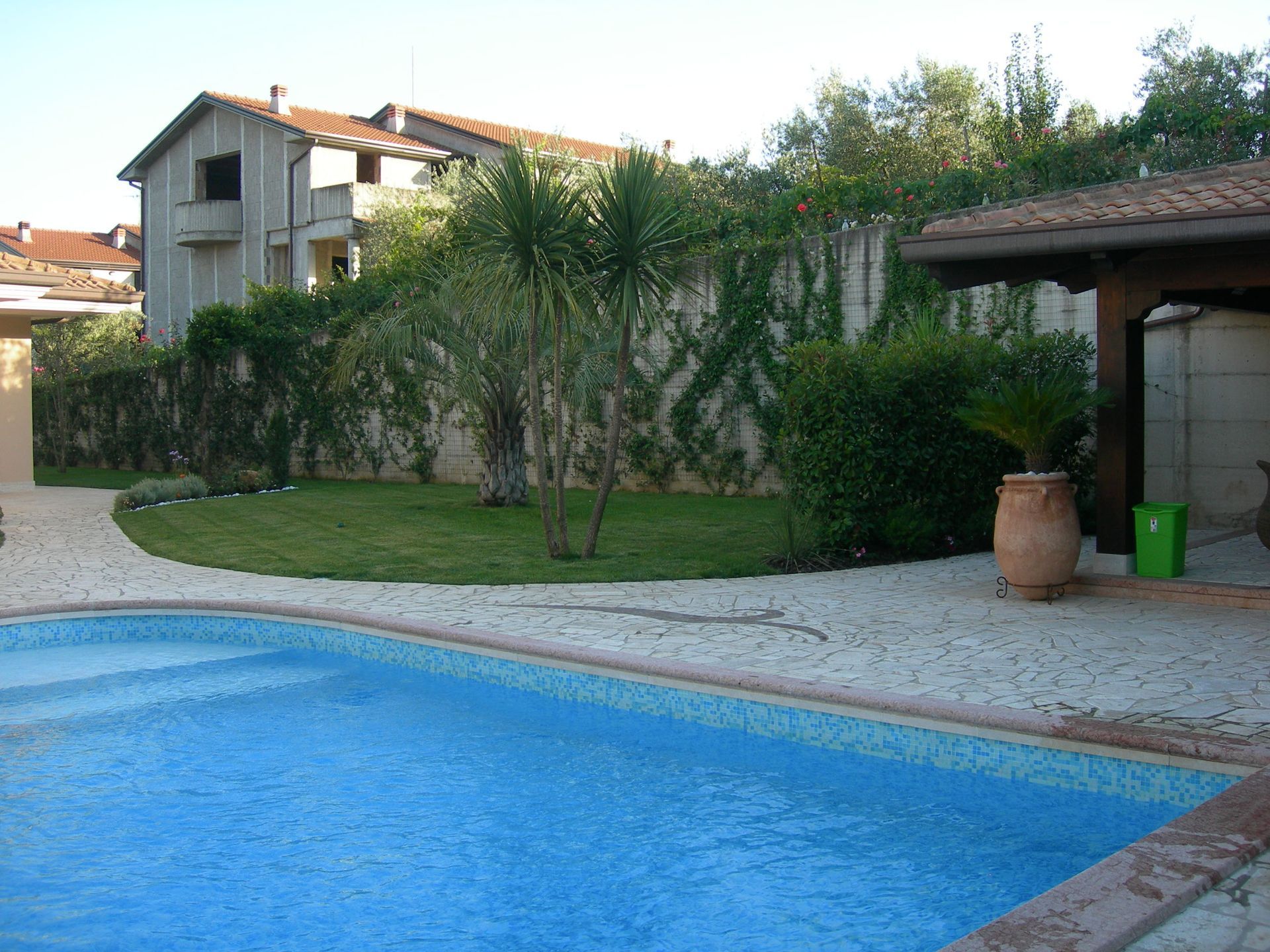 Una grande piscina con una casa sullo sfondo