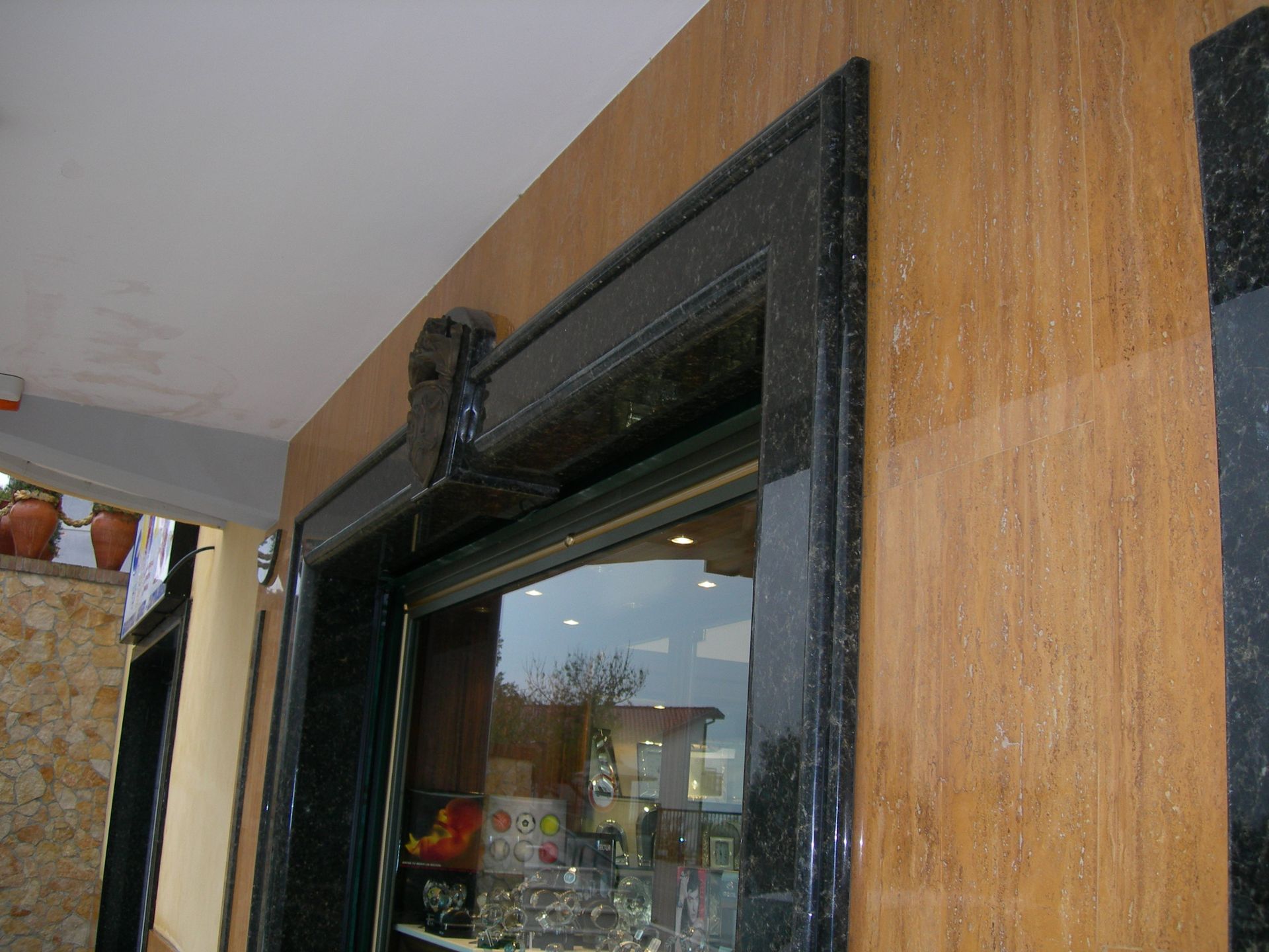 Una finestra con una cornice nera su una parete di legno