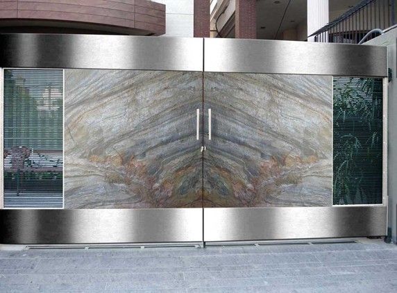 Di fronte a un edificio c'è un cancello in acciaio inossidabile con un disegno in marmo.