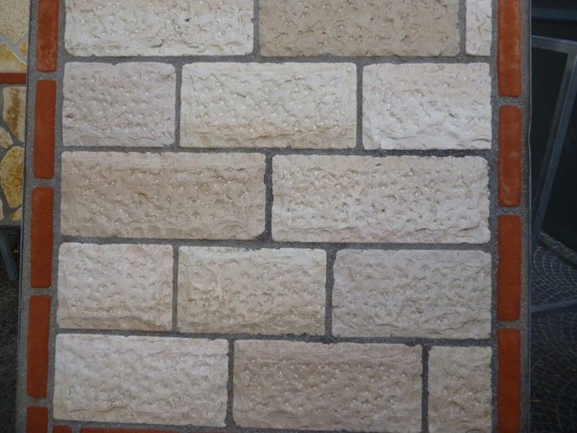 Un primo piano di un muro di mattoni con un bordo rosso