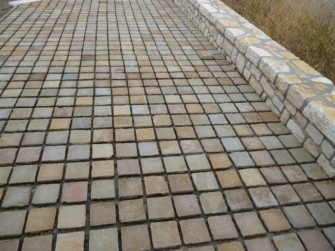 Un marciapiede in mattoni con un cordolo in mattoni sul lato