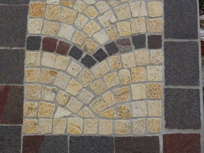 Un primo piano di un pavimento in mattoni con un motivo circolare