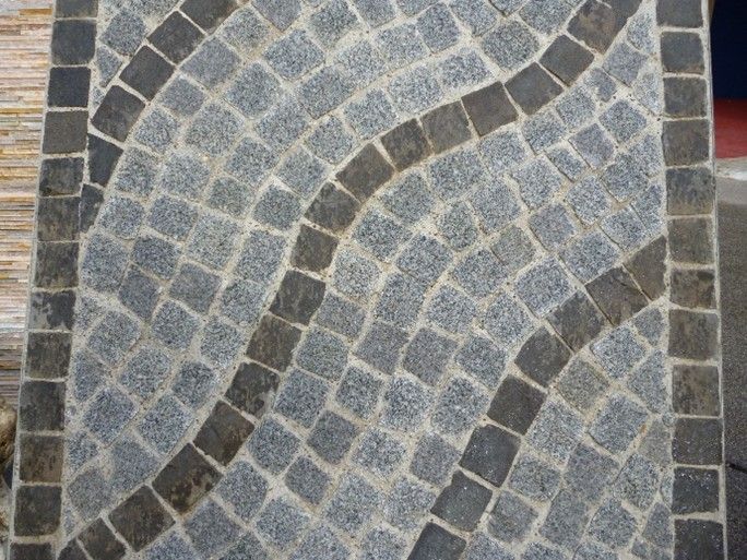 Un primo piano di un marciapiede in ciottoli con un motivo circolare