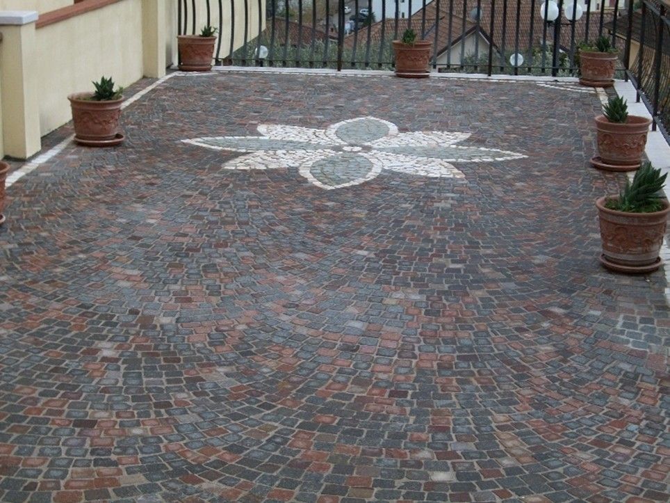 Un patio con piante in vaso e un disegno a mosaico