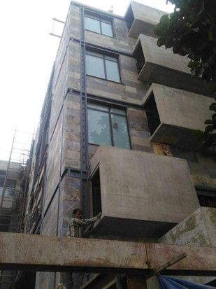 Un uomo è in piedi sul balcone di un edificio in costruzione.