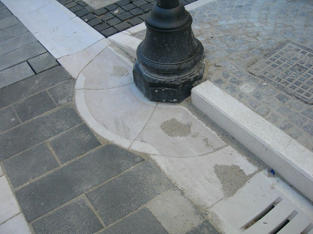 Un lampione nero è appoggiato su un marciapiede di mattoni