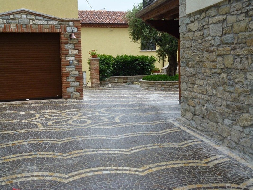 Un vialetto con un muro di pietra e una porta da garage