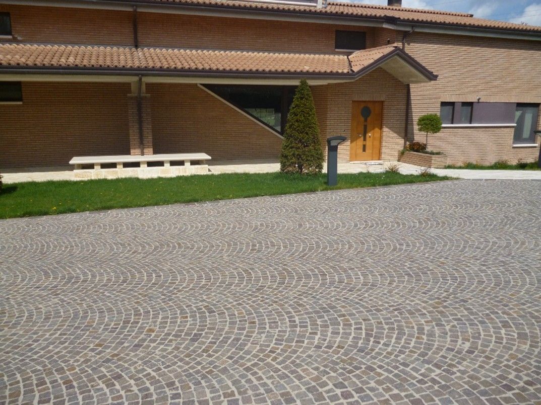 Una casa di mattoni con un vialetto di ciottoli davanti