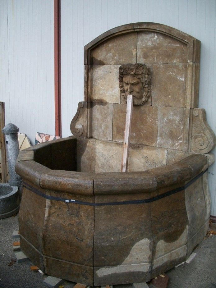 Una grande fontana di pietra con un volto sopra