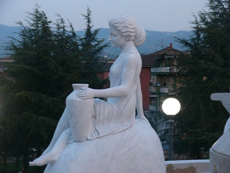 Una statua bianca di una donna che regge un vaso