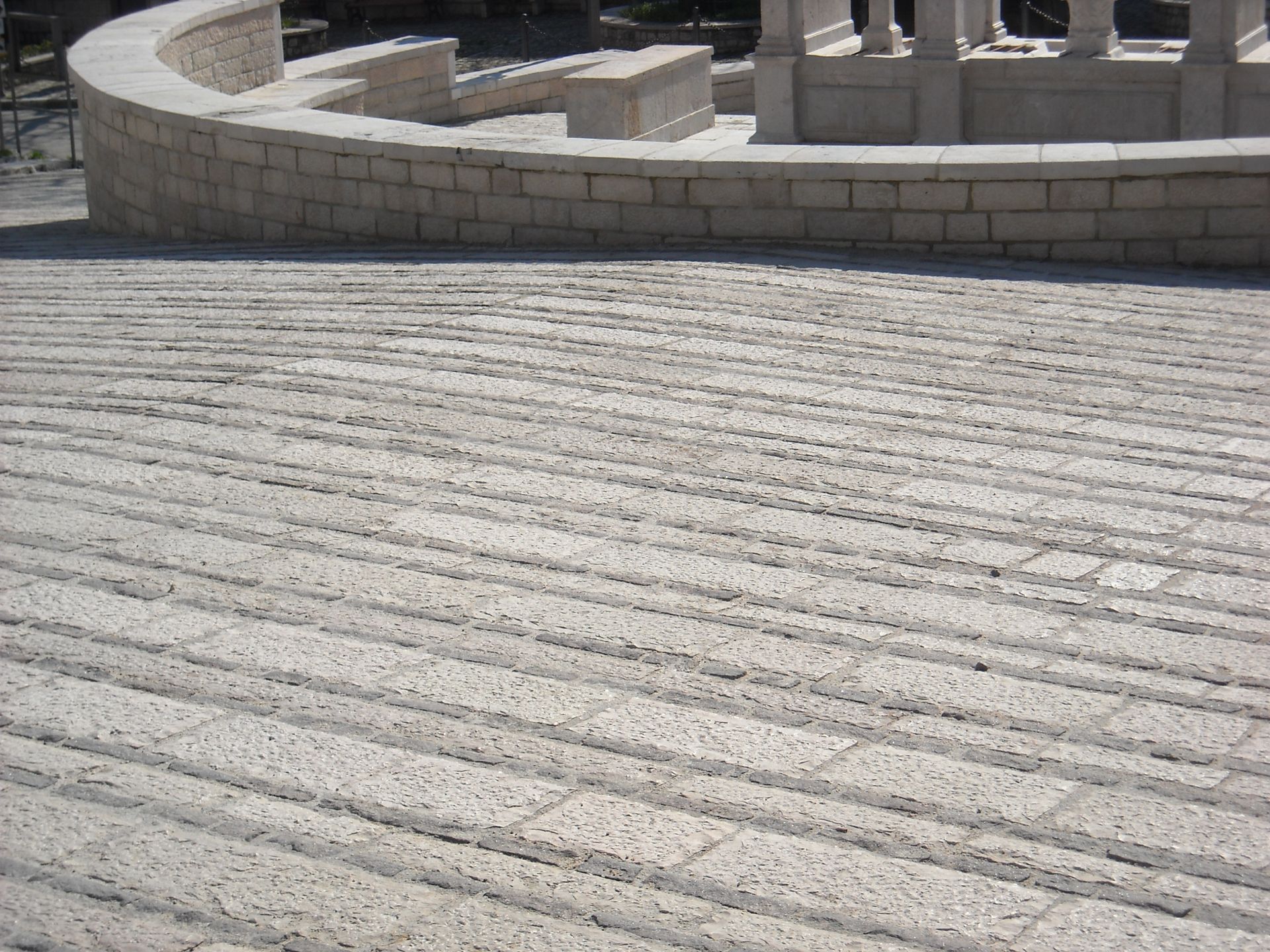 Una passerella in mattoni con un muro curvo sullo sfondo