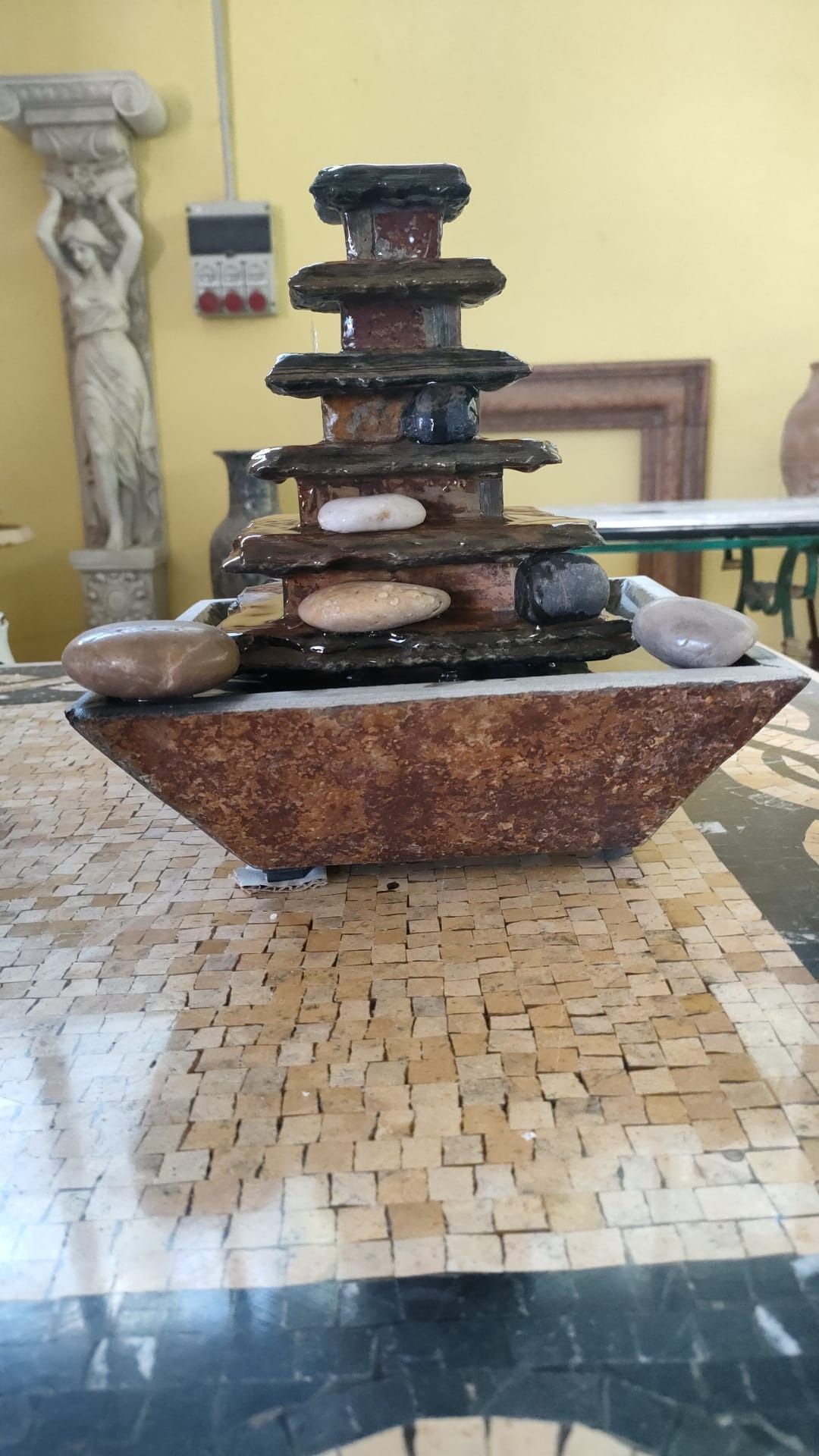 Una piccola fontanella è posta sopra un tavolo.