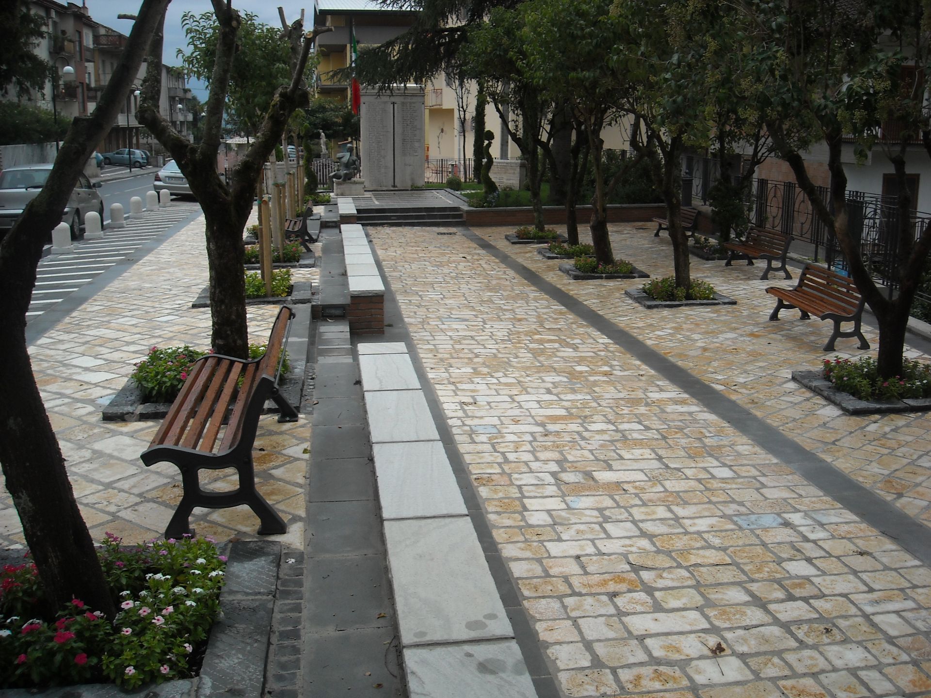 Una passerella di mattoni con una panchina di legno al centro