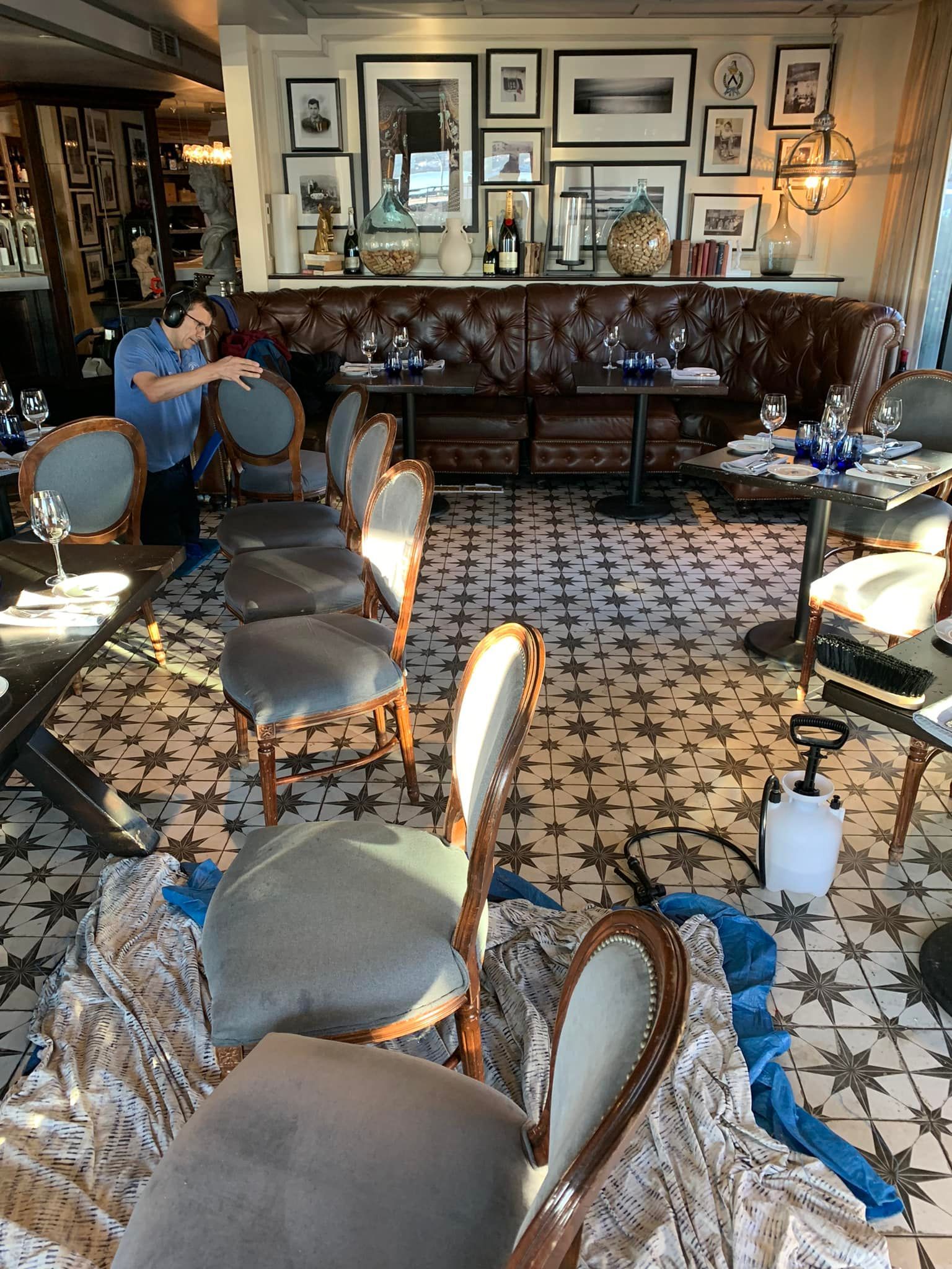 A man is cleaning chairs in a restaurant.