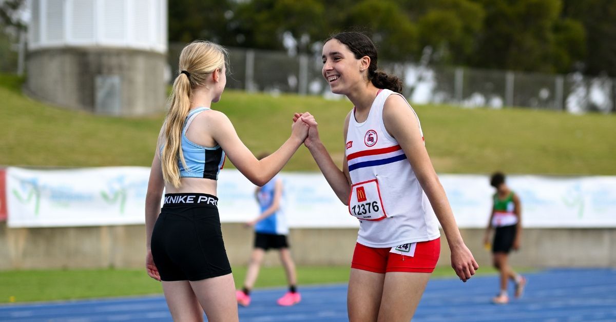 Two Little Athletics participants shake hands after a race.