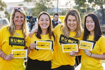 Group of women smiling with R U OK? Signs