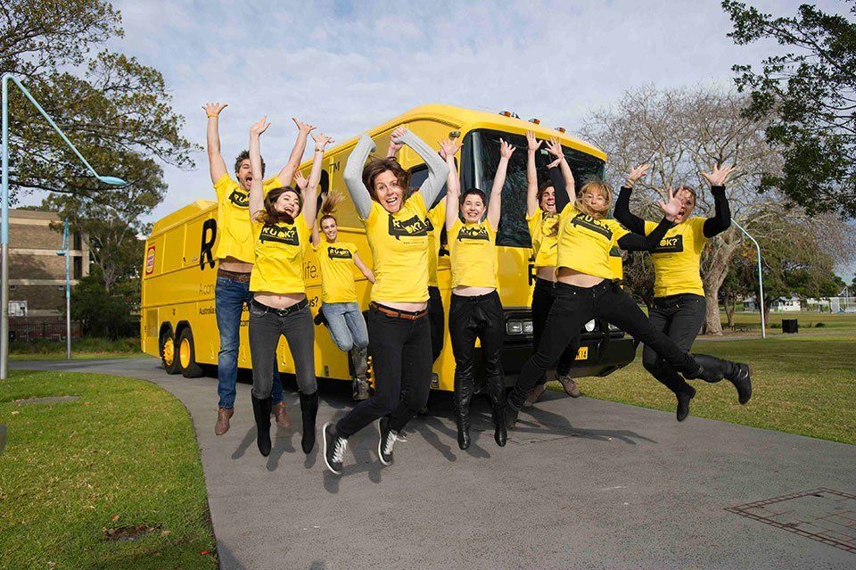 The bright yellow R U OK? bus on site in Darwin with volunteers