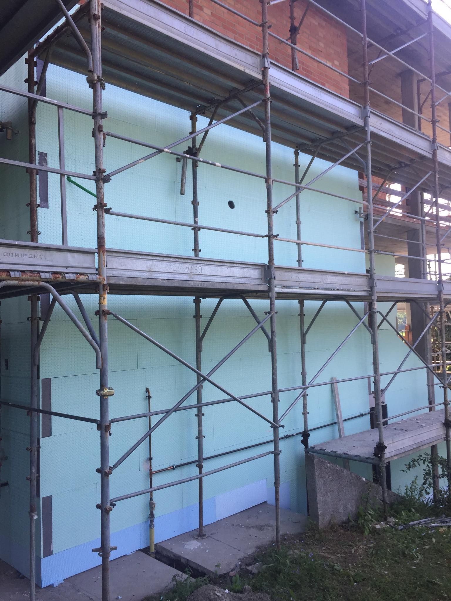 Rullo per applicare vernice rossa brillante su una superficie bianca.