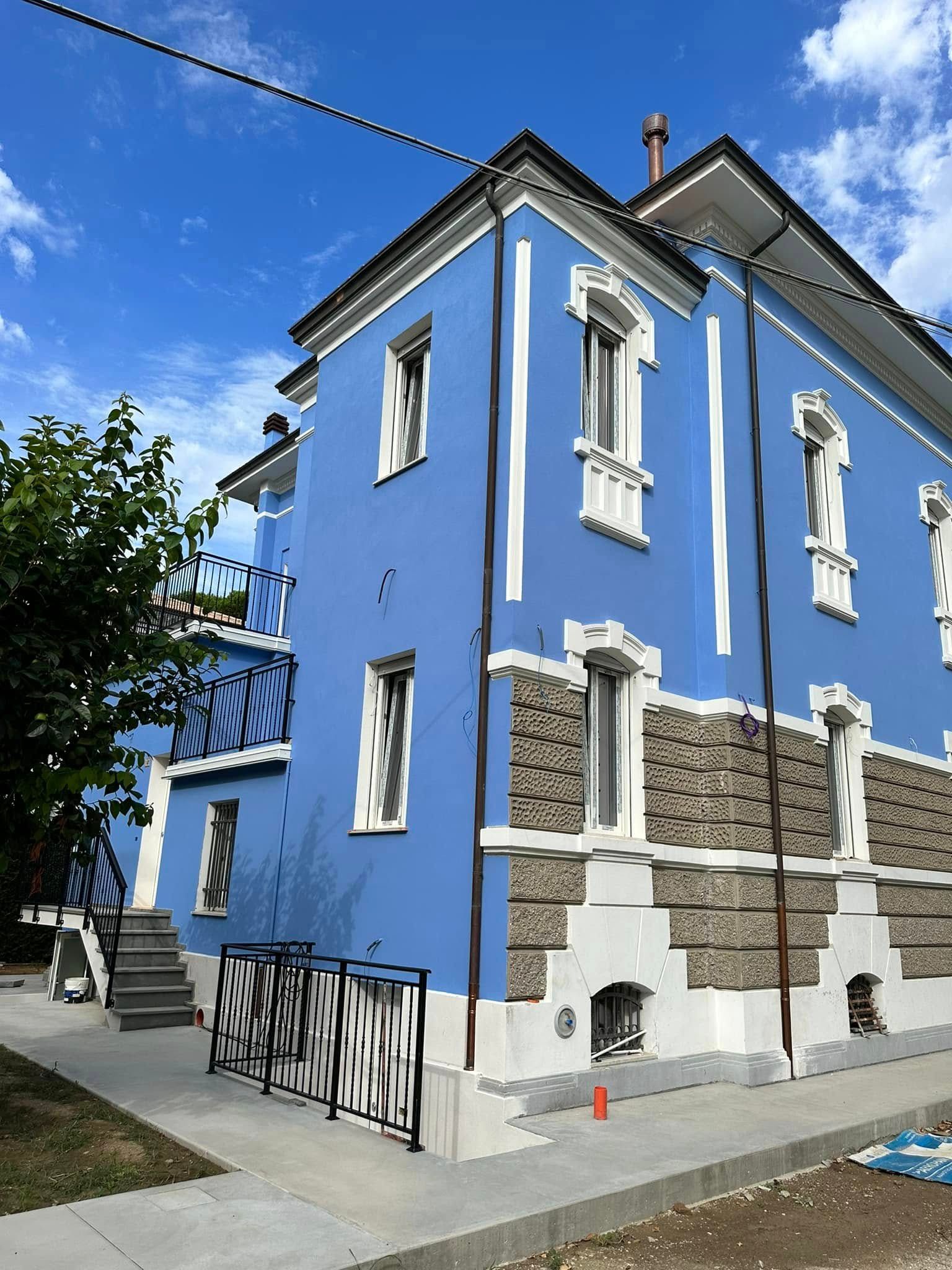 Rullo per applicare vernice rossa brillante su una superficie bianca.