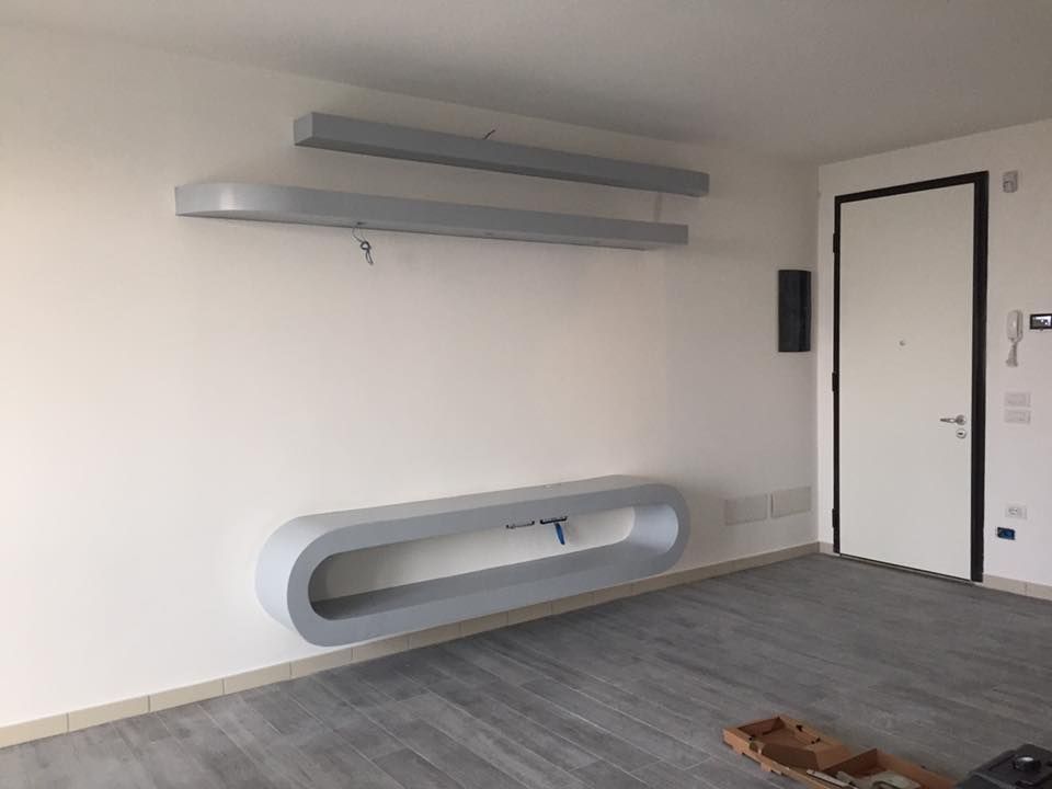 Rullo per applicare vernice rossa brillante su una superficie bianca.