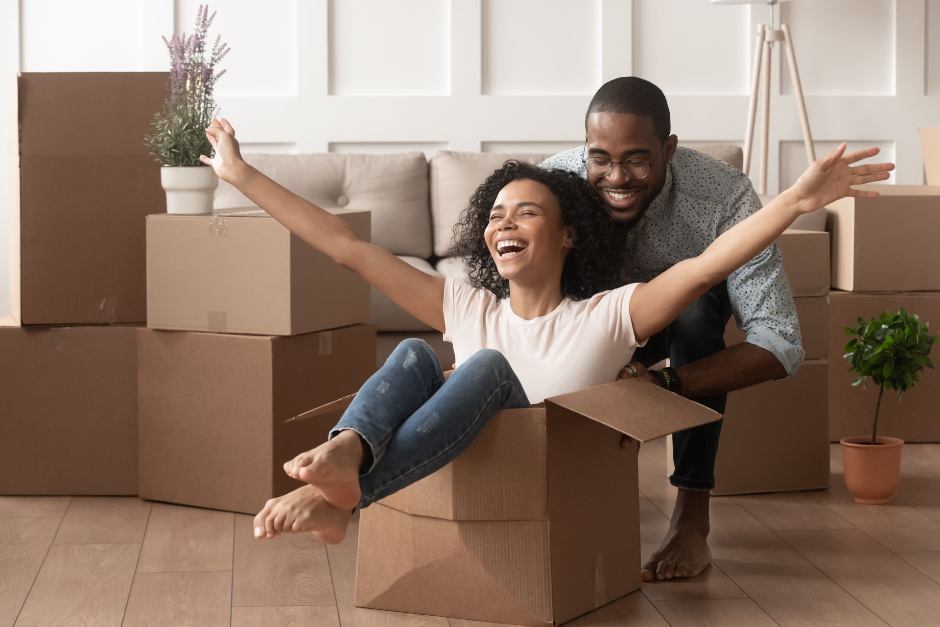 Couple enjoying a stress-free moving day with packed boxes in their living room
