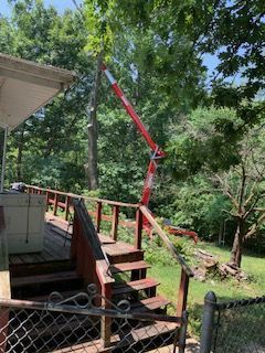 A red crane is sitting on top of a wooden deck.
