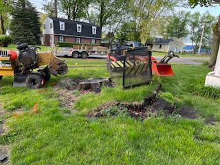 A stump grinder is being used to remove a tree stump in a yard.