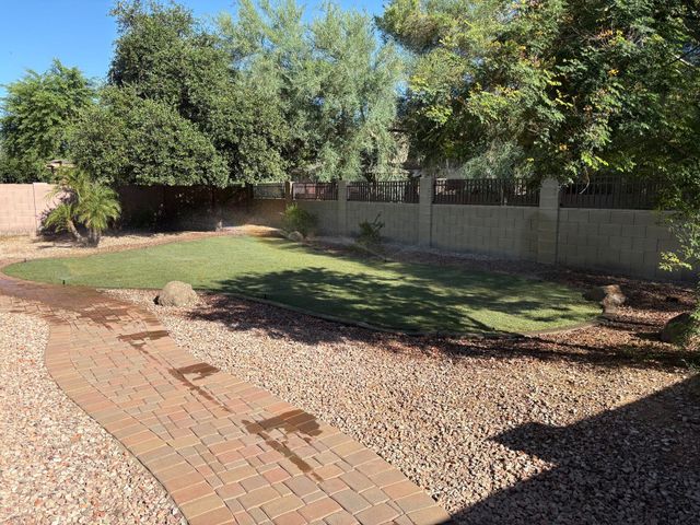 Gardener planting in a landscaped bed, with a variety of plants and black landscaping fabric.