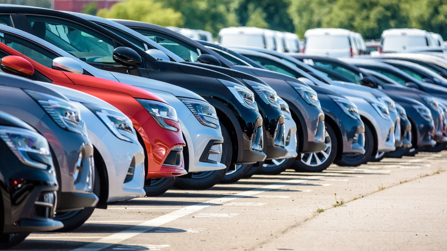 Cars parked in a row, with varying colors including red, black, and silver. Outdoors, sunny day. | Brakes At Your Place