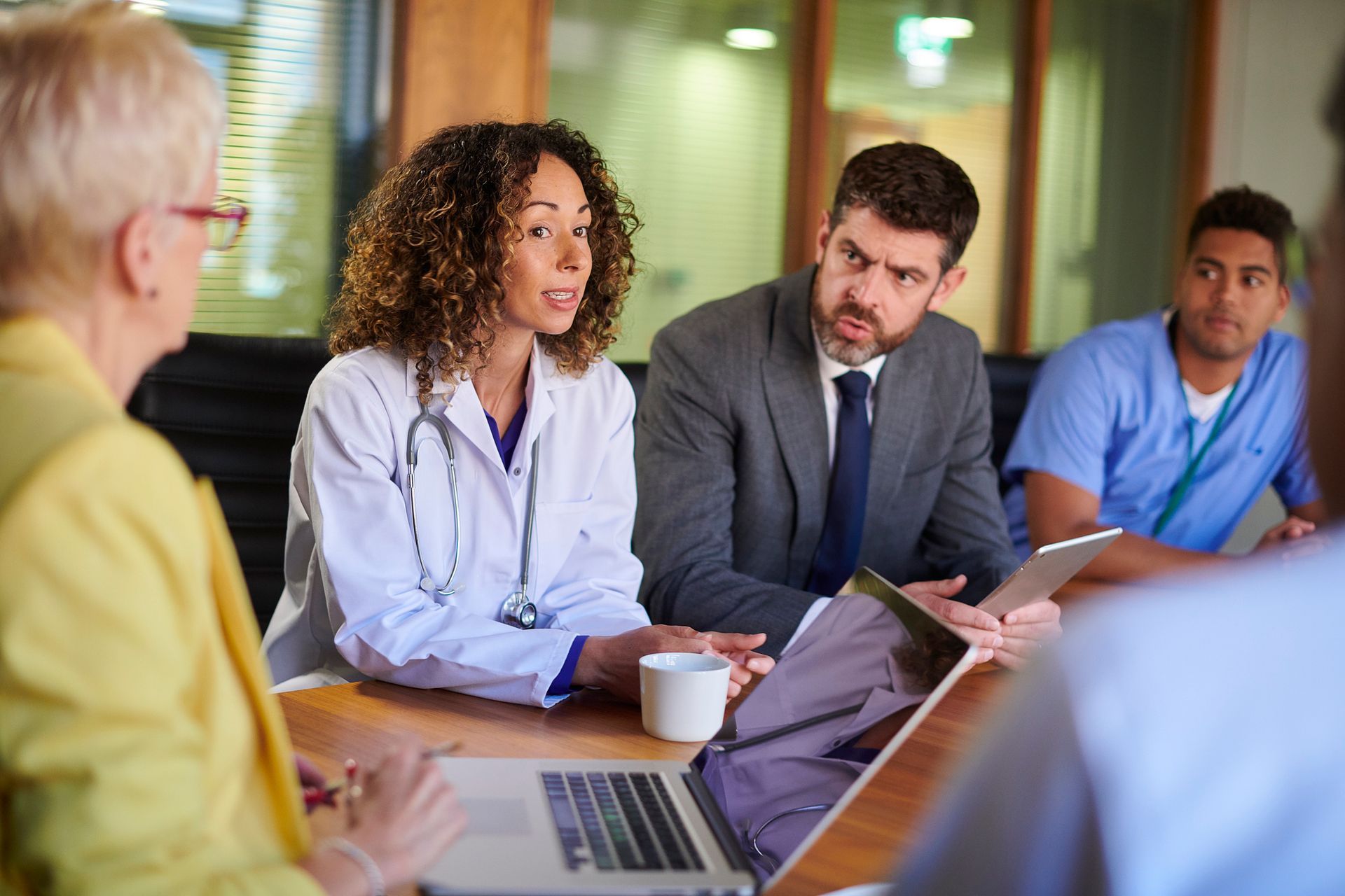 A group of doctors and nurses are having a meeting in a conference room.