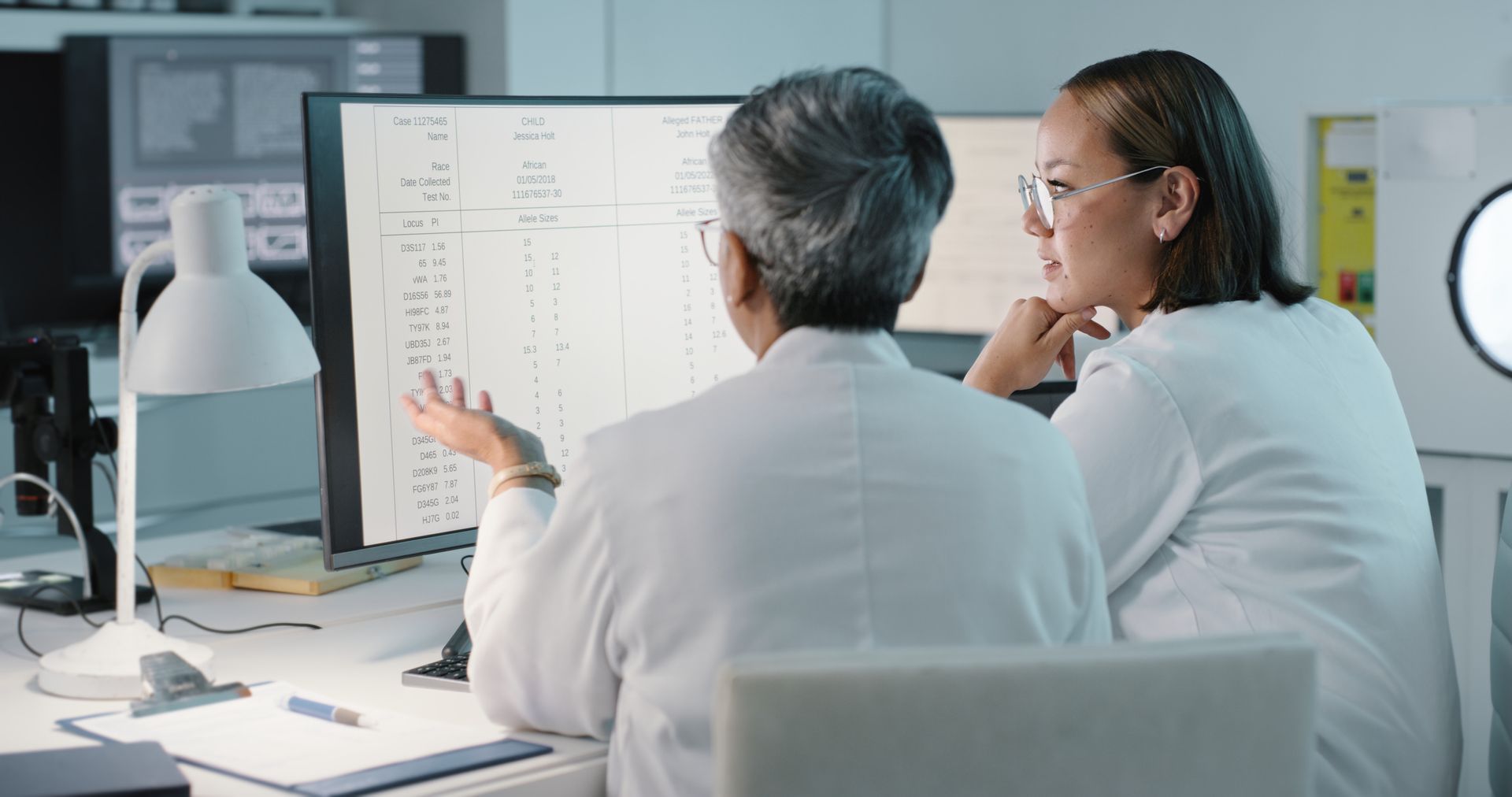 Two scientists are looking at a computer screen in a laboratory.
