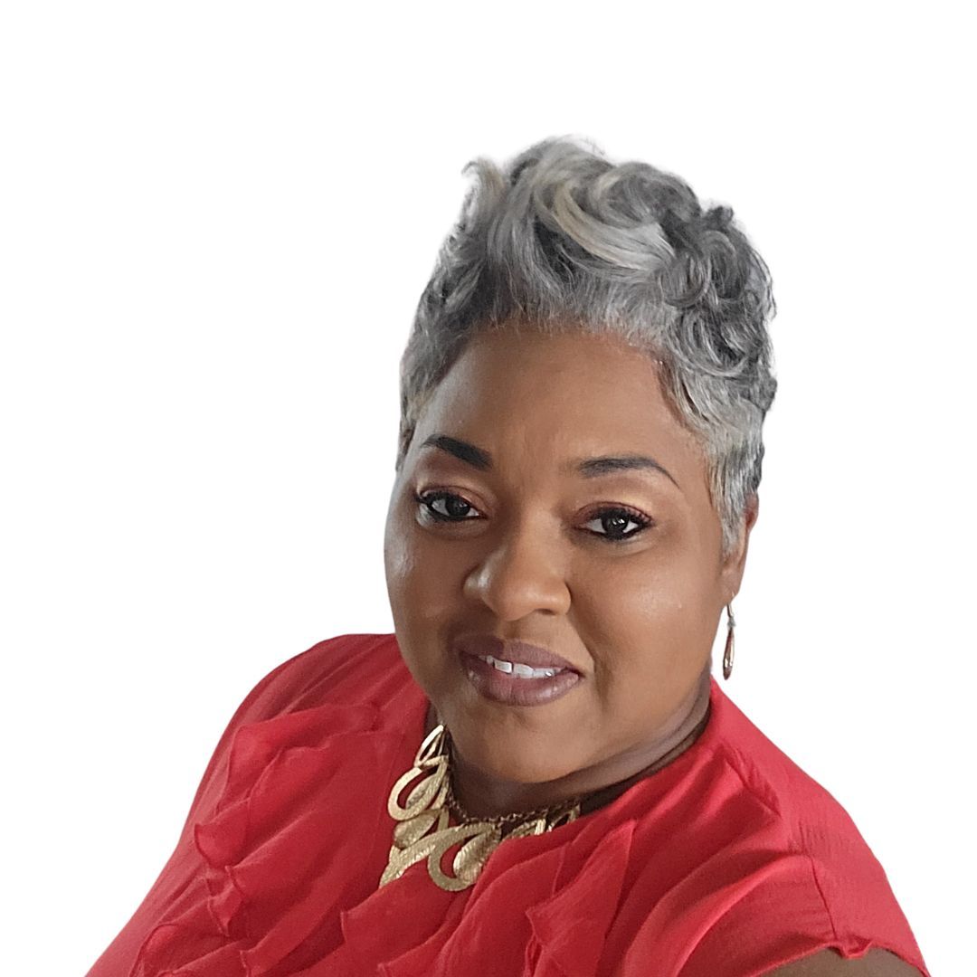 A woman with gray hair is wearing a red top and a gold necklace