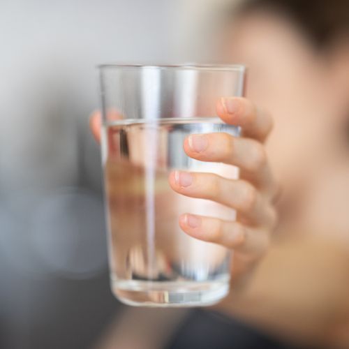 Hand holding a glass of water.