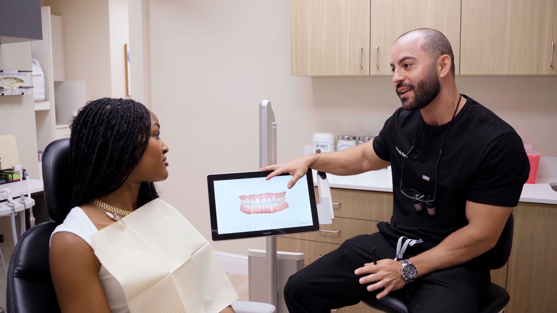Dentist showing a patient a digital image of teeth in a clinic.