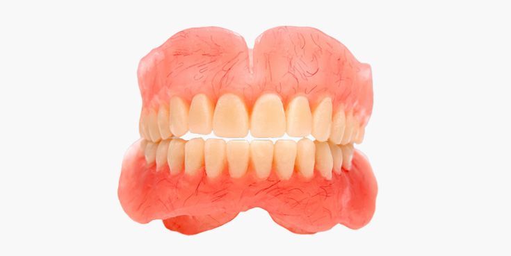 Dentures, false teeth with pink gums and white teeth, isolated on white background.