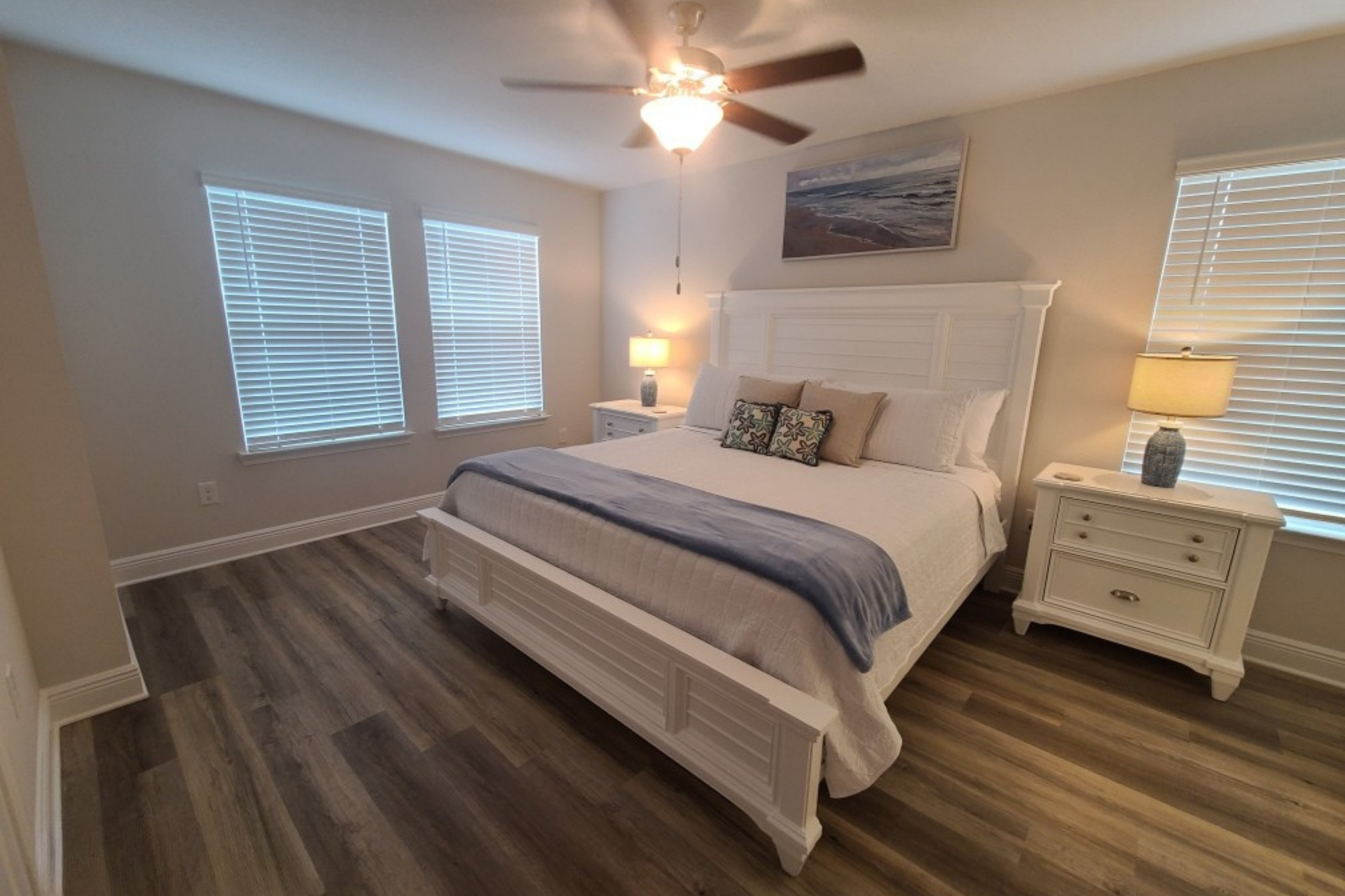Bedroom with white furniture, gray floors, and a blue and white color scheme.