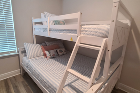 Bright and comfortable bunk bedroom with a twin-over-full bunk bed, coastal bedding, and ladder access—perfect for kids at our Panama City Beach vacation rental. Twin over full bunk bed bedroom for kids at a Panama City Beach vacation rental