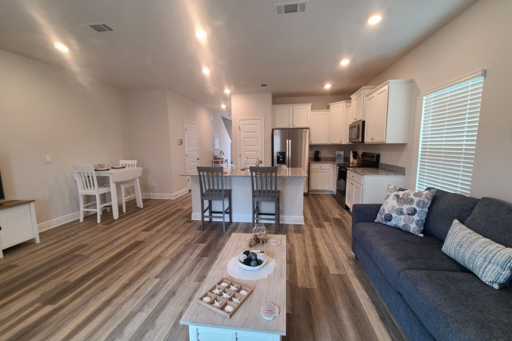 Open concept living room and kitchen with island seating at a Panama City Beach vacation rental
