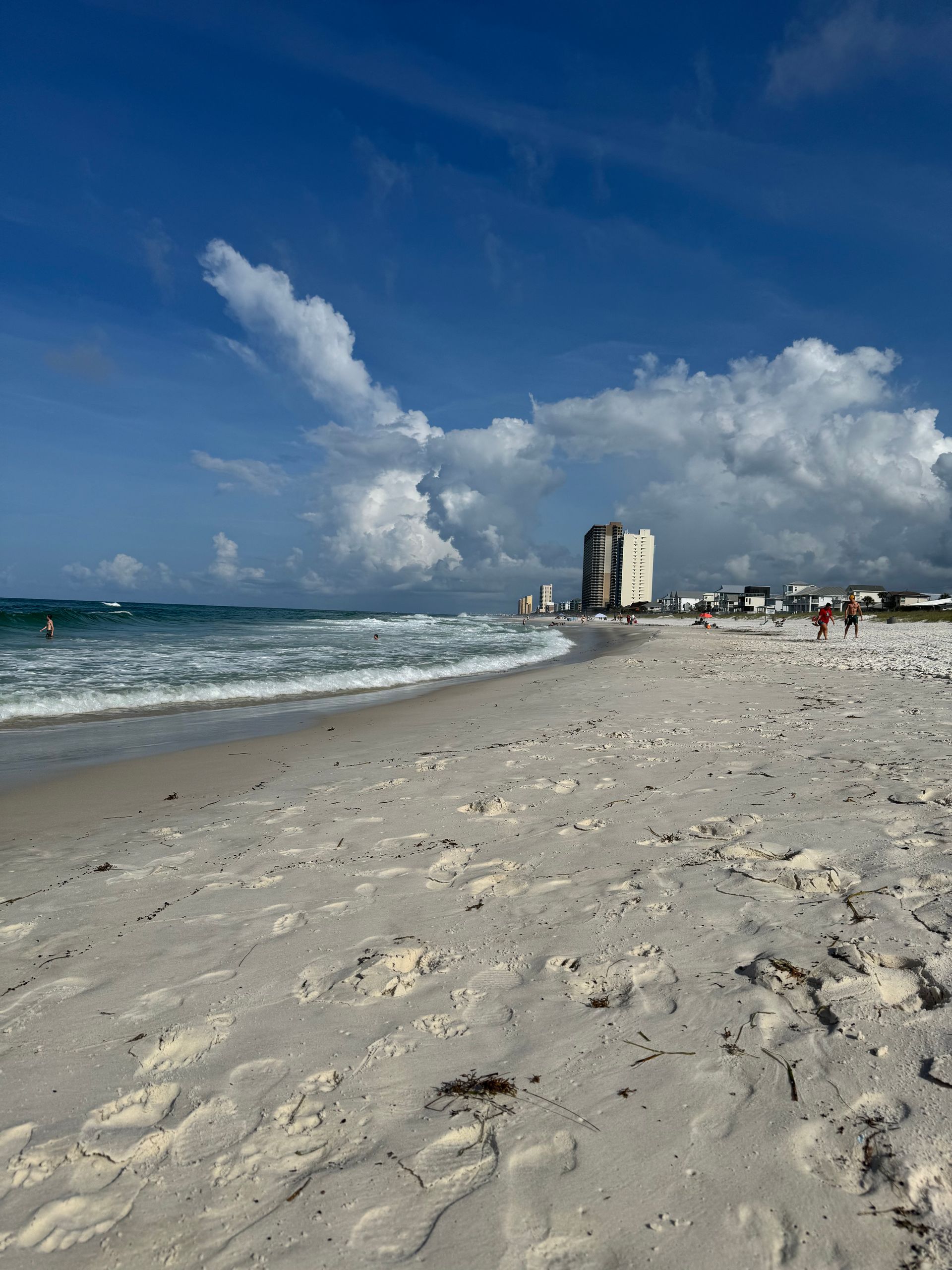 White sand beach with Gulf waves and beachfront condos in Panama City Beach Florida
