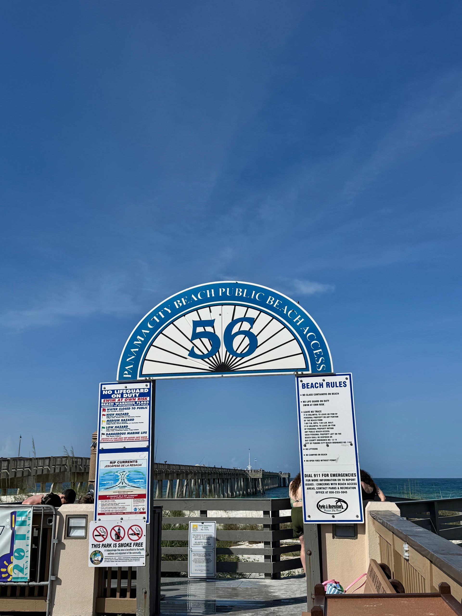Public Beach Access 56 sign and entrance in Panama City Beach Florida with pier and Gulf shoreline
