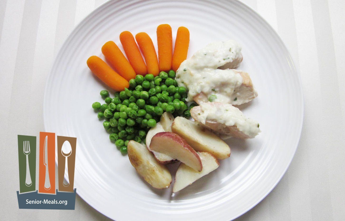 Chicken Breast with Tarragon Cream Sauce, Potatoe Wedges, and Peas and Baby Carrots